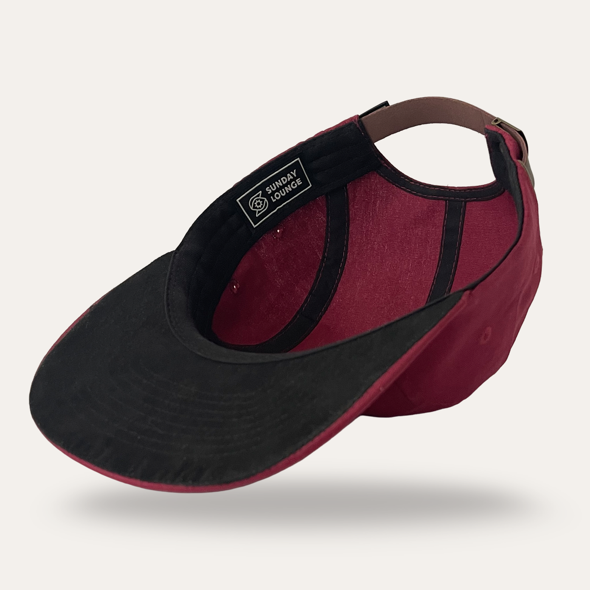 Interior view of Sunday Lounge Bee Eye Hat in burgundy with black brim and adjustable leather strap