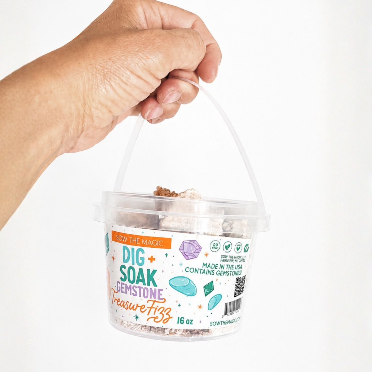 Hand holding a Sow the Magic Dig and Soak Surprise Gemstone Treasure Fizz bucket