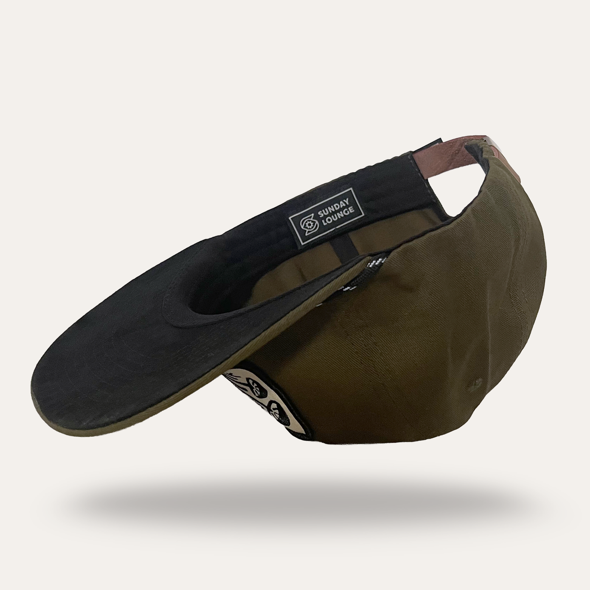 Interior view of Sunday Lounge Mushroom Hat in forest cotton twill showing brand label and adjustable strap