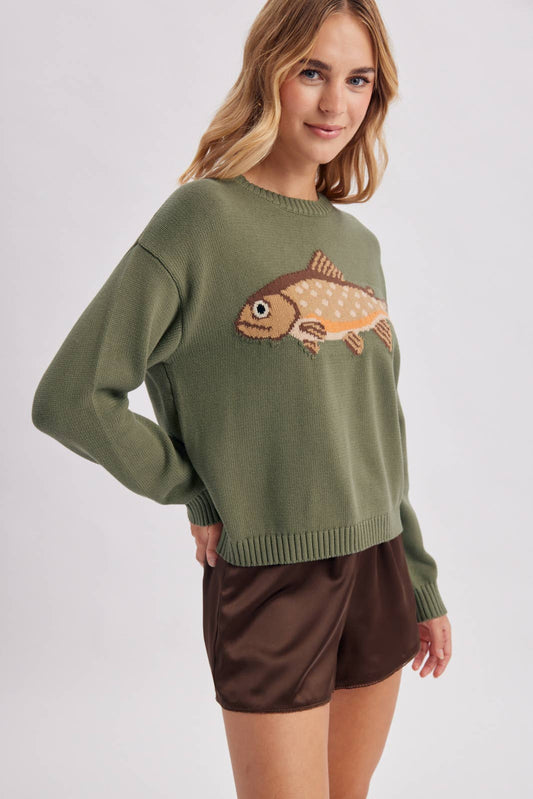 Woman wearing a green sweater with a fish design on a white background