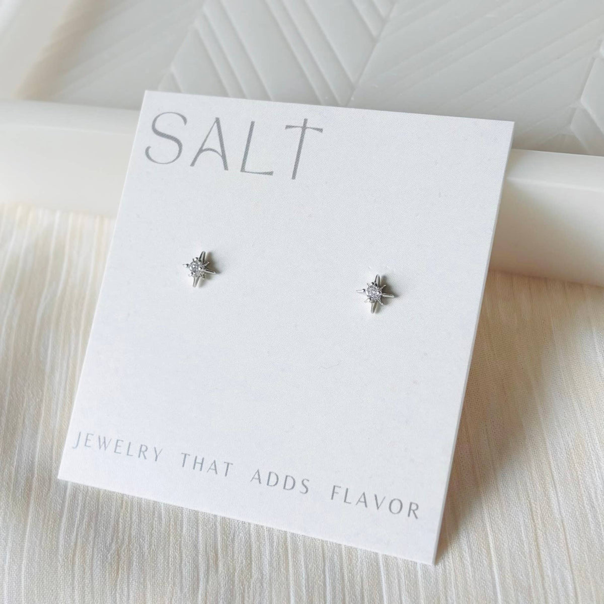 Silver star stud earrings by SALT by Sarah Curtis on branded display card