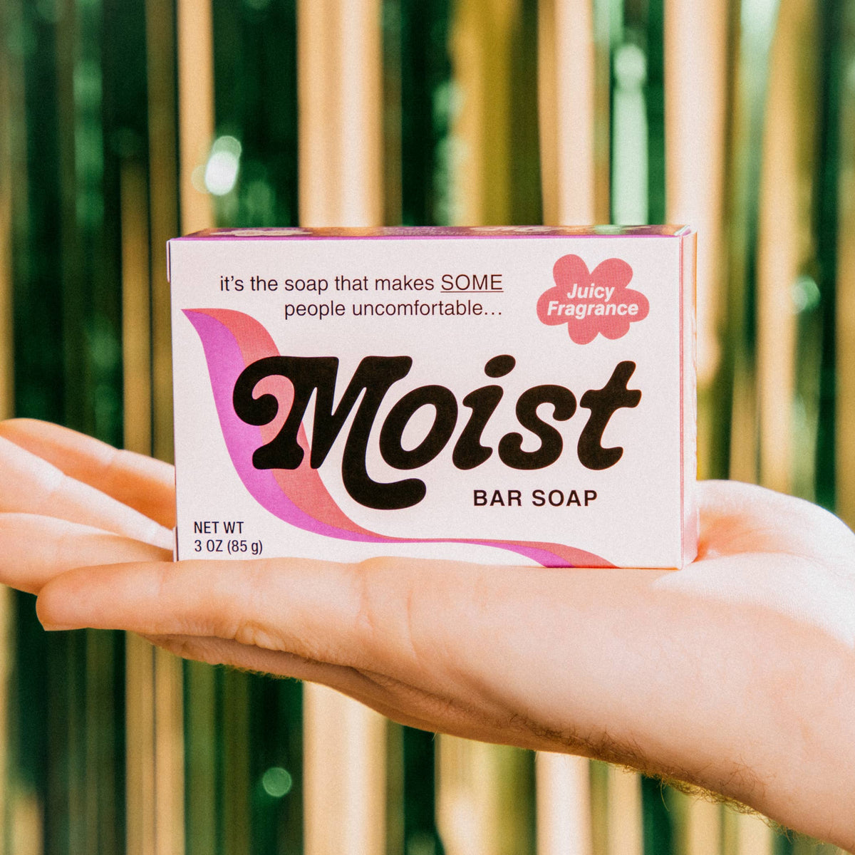 Whiskey River Soap Co Moist triple milled bar soap in a box held in a hand