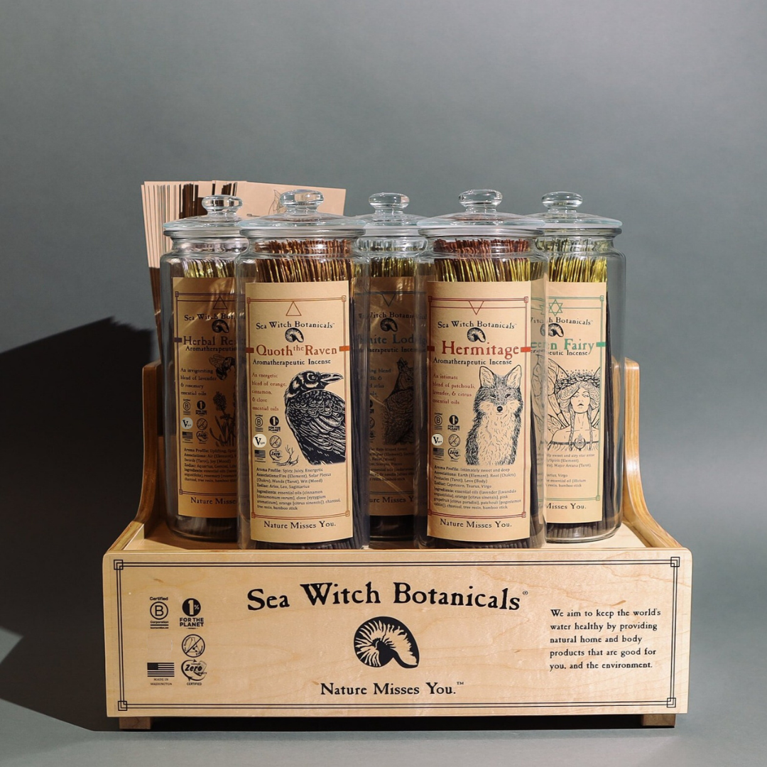 Sea Witch Botanicals wooden display stand with five glass jars of Herbal Renewal lavender and rosemary incense sticks