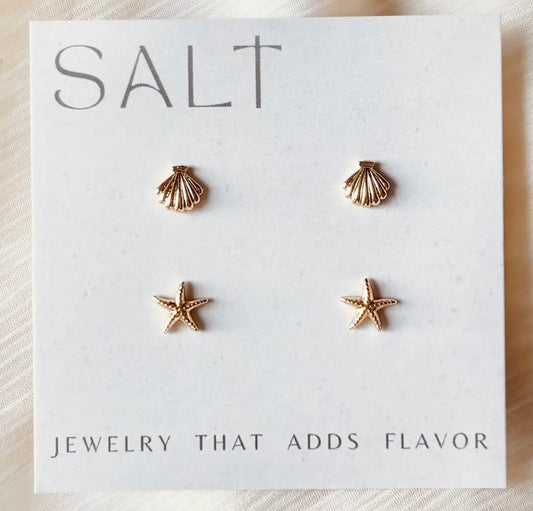 Two pairs of gold-tone coastal stud earrings featuring textured seashells and starfish, displayed on a white jewelry card.
