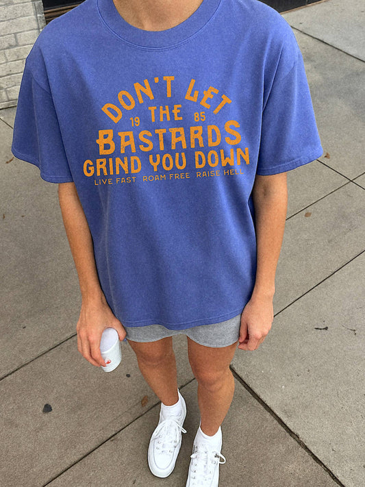 Person wearing a blue t-shirt with a motivational quote on a sidewalk.