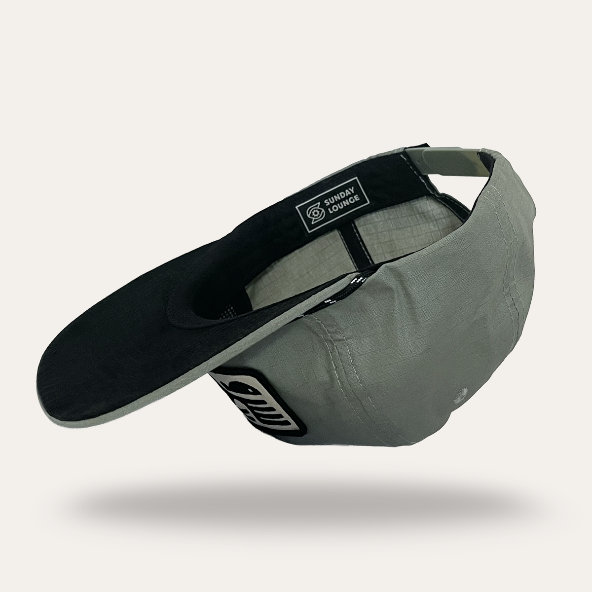 Sunday Lounge Pelican with Fish Hat in sage cotton ripstop showing interior branding and adjustable strap