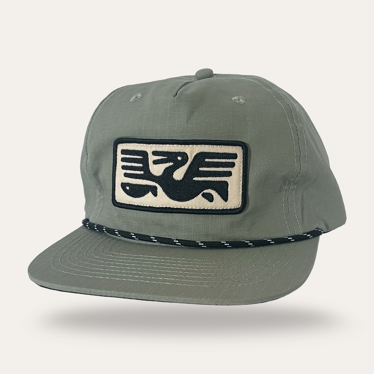 Sunday Lounge sage cotton ripstop cap with a black and cream pelican graphic patch and a black rope detail