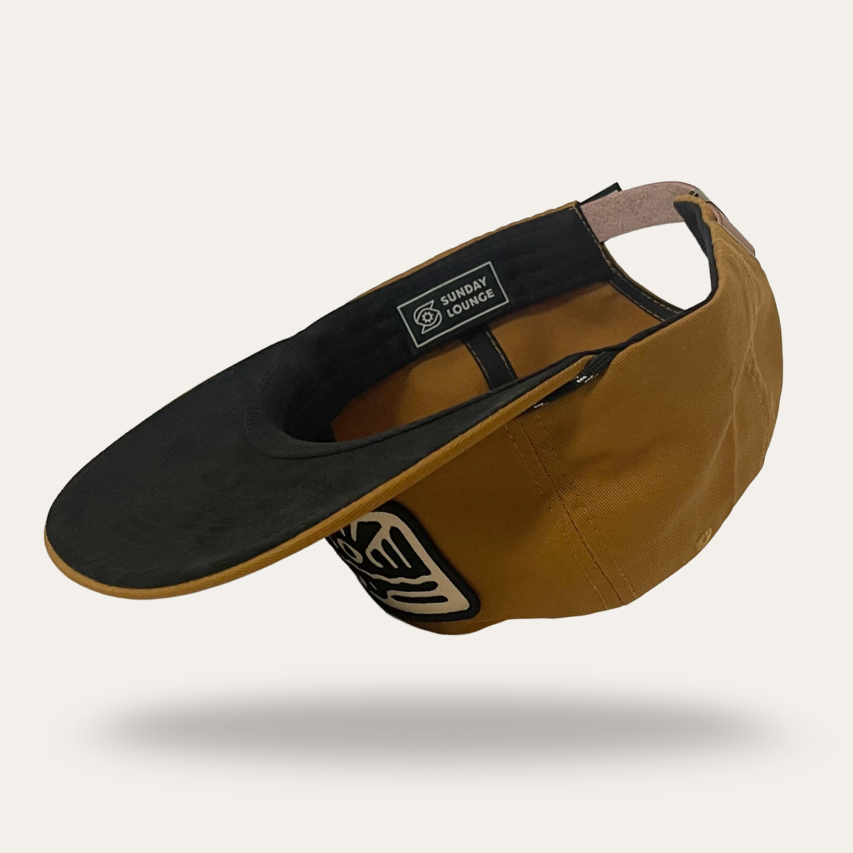 Interior view of Sunday Lounge Spirit Wing Bird Hat in umber cotton twill with black brim and branded label