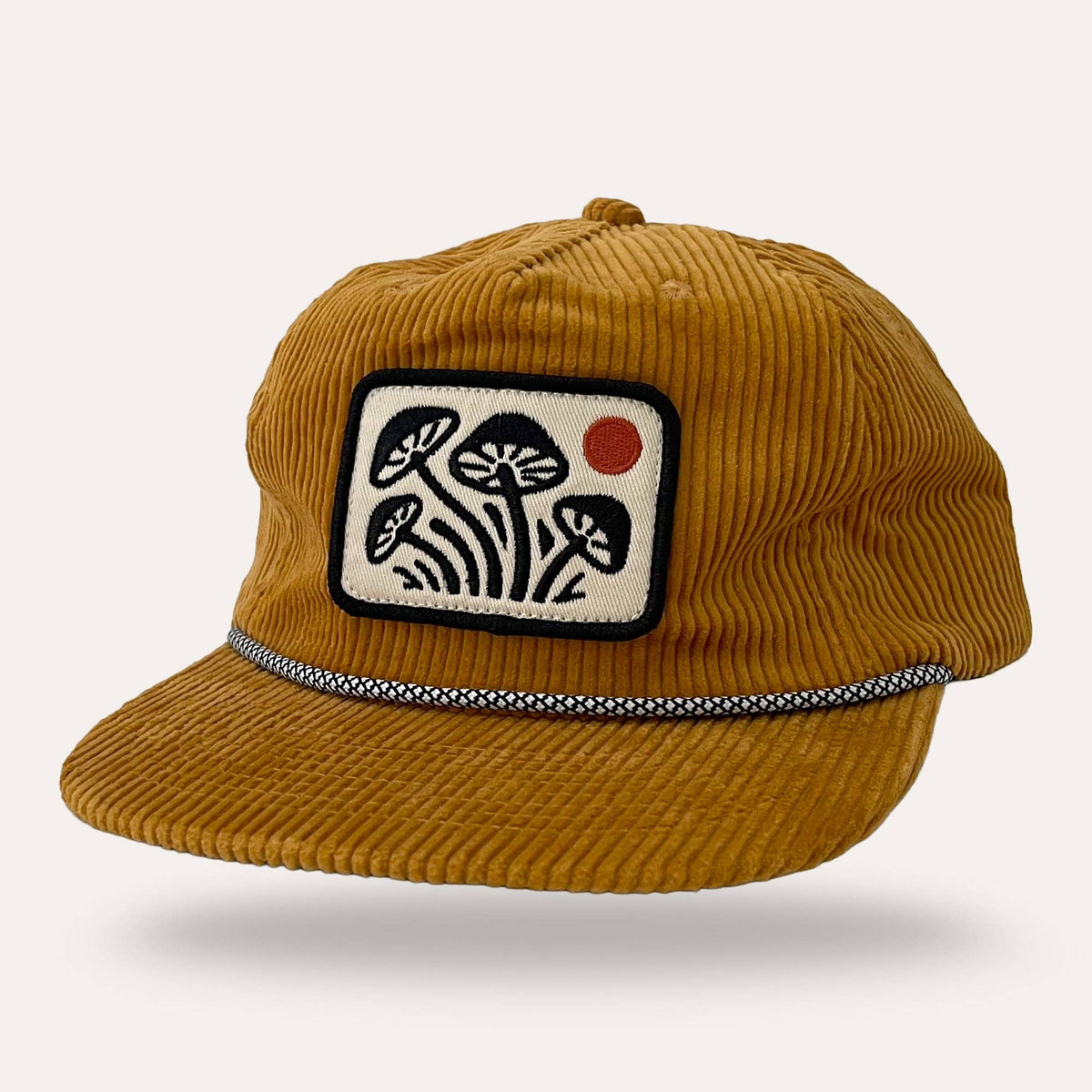 Sunday Lounge mustard corduroy mushroom hat with a rectangular patch featuring black mushrooms and a red sun