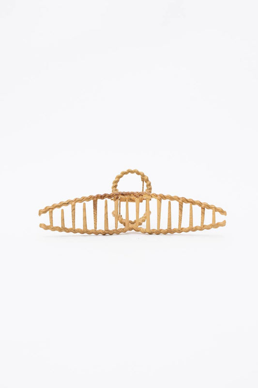 A single woven hair claw clip in a natural light tan color, photographed against a seamless white background.
